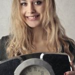 Scale Photography - Woman in Black Shirt Holding Black and Silver Weight Scale